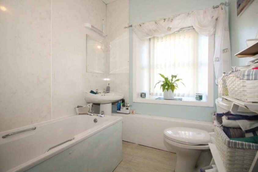 Bright and open bathroom with sink, toilet and bath.