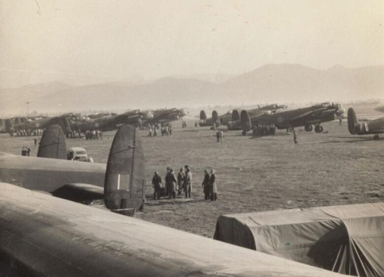 Several Lancasters parked on a grass field at Pomigliano airfield, Naples for Operation Dodge. 