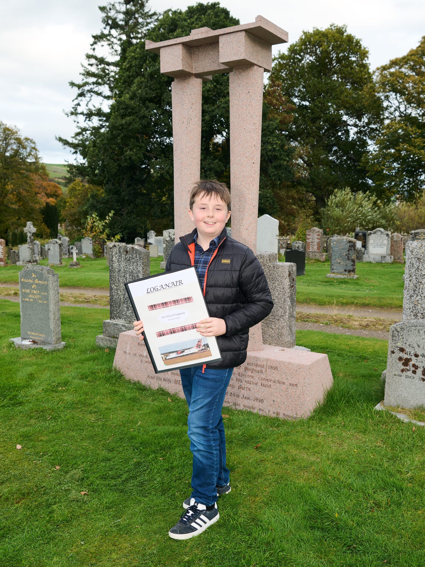 Struan Eason standing in front of headstone 