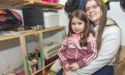 Susan Manson, pictured with her daughter Merran, bent down next to a storage unit.