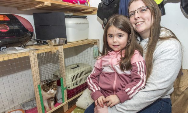 Susan Manson, pictured with her daughter Merran, bent down next to a storage unit.