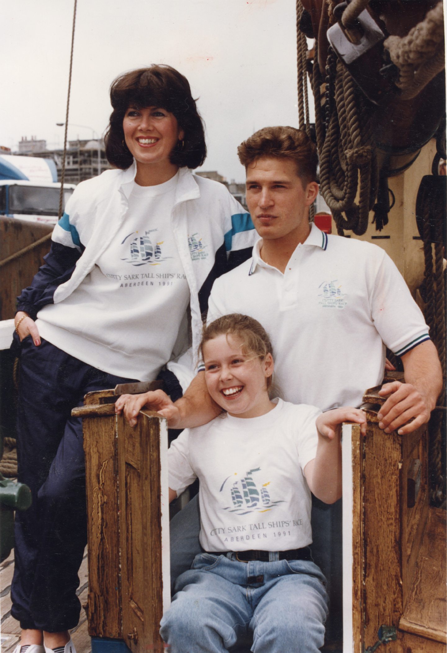 Tall ships clothing being modelled on three models on board one of the ships