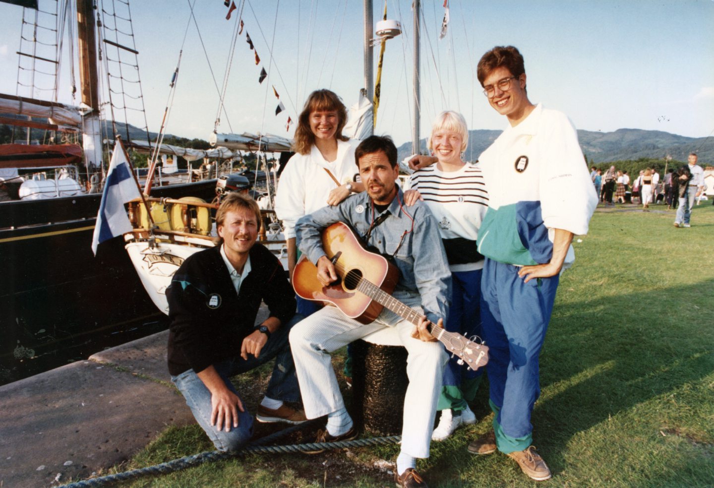 the crew of the Finnish sail training ship Lokki next to the ship, one of them holding a guitar