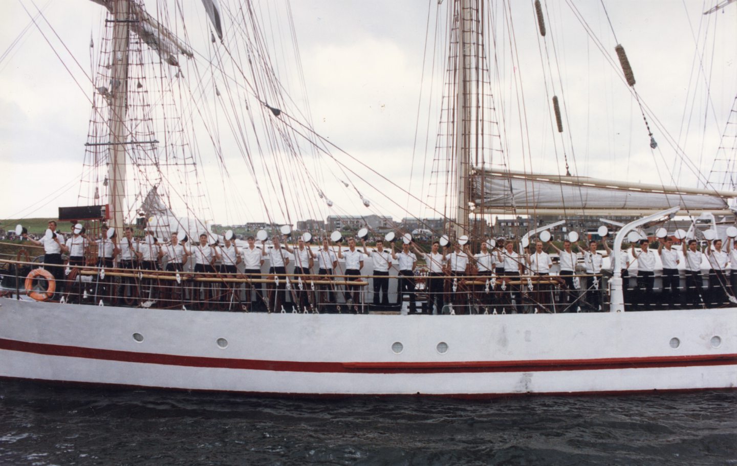  Crew of the barquentine the Iskra, from Poland, chant out the name of their vessel as their doffed headgear is waved to the crow in unison