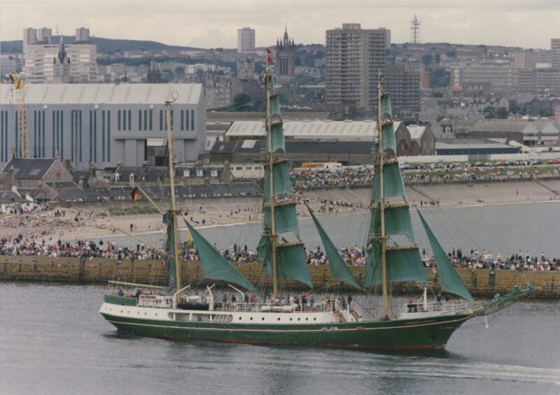 A large green-sailed tall ship, with Aberdeen beach in the background when the event visited in 1991.