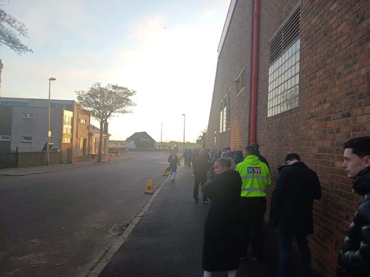 Aberdeen FC supporters queue outside stadium.