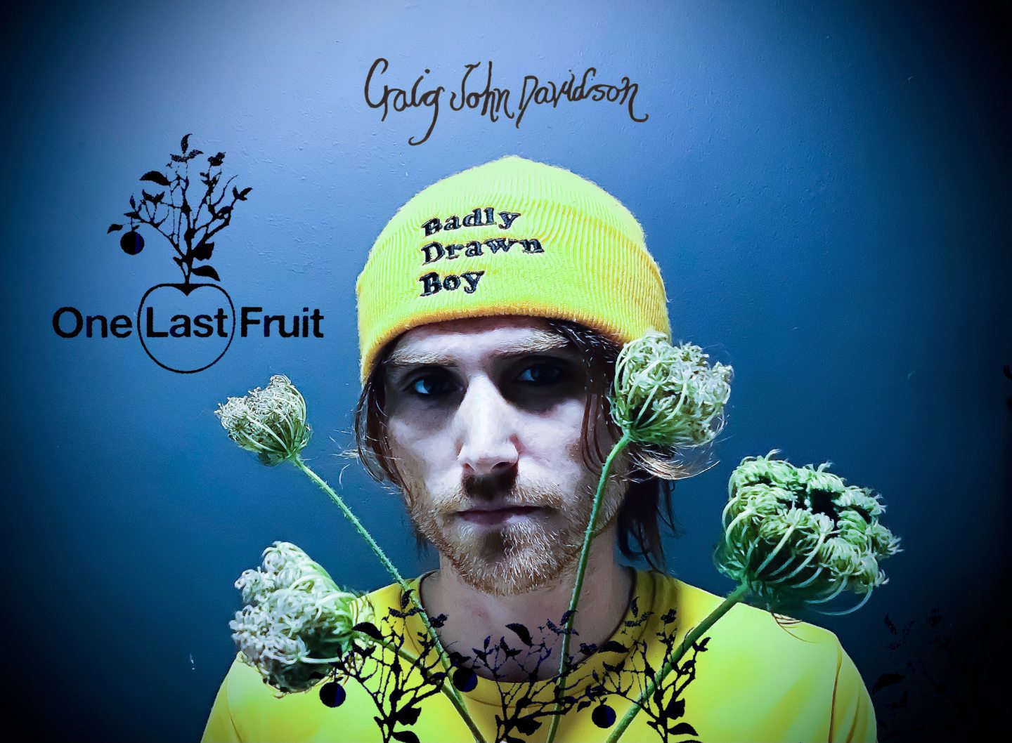 Aberdeenshire musician Craig John Davidson wearing a beanie hat with the words 'Badly Drawn Boy' and holding dried flowers.