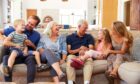 Happy family of grandparents, parents and children on sofa