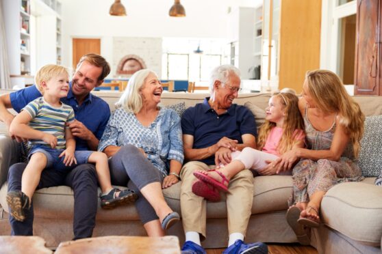 Happy family of grandparents, parents and children on sofa