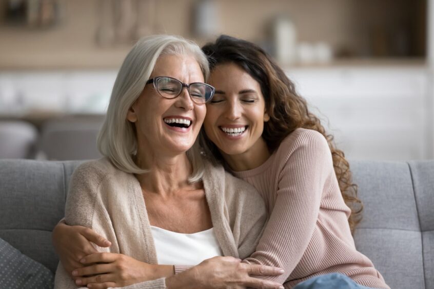 Mother and adult daughter laughing together