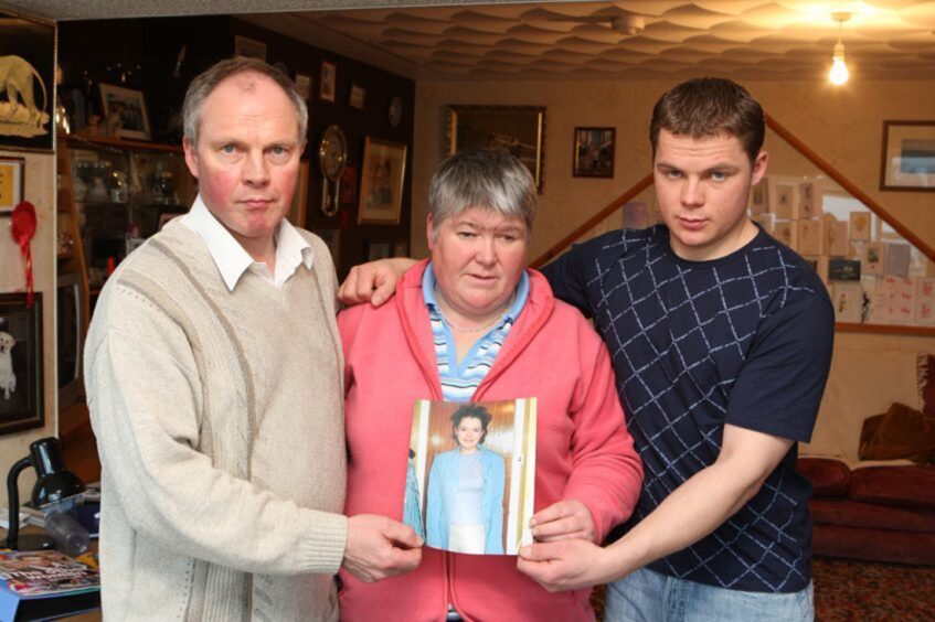 The Aim family, from left Brian, Peggy and brother Allan holding a photograph of Karen.