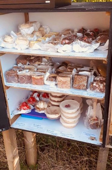 Crate with shelves full of cakes. 