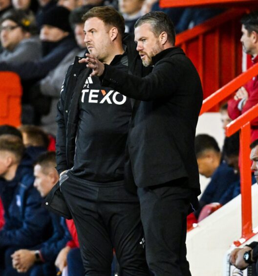 Aberdeen manager Jimmy Thelin (R) speaks to first team coach Peter Leven during 4-1 win against Dundee. Image: SNS