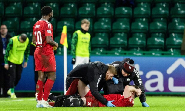 Aberdeen's Nicky Devlin goes down with an injury during the 3-3 draw with Hibs at Easter Road. Image: SNS