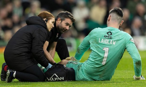 Ross County goalkeeper Ross Laidlaw receives treatment for his injury at Celtic Park on Saturday. Image: SNS.