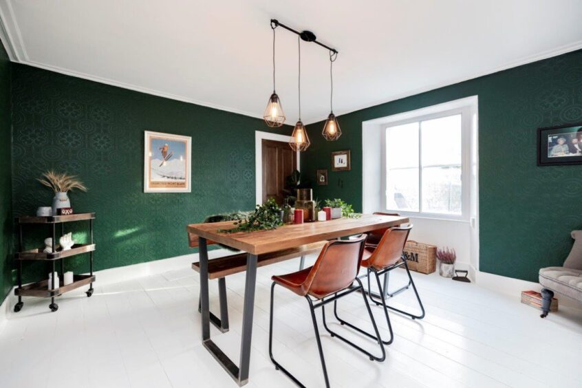 Dining table and chairs on a whitewashed floor