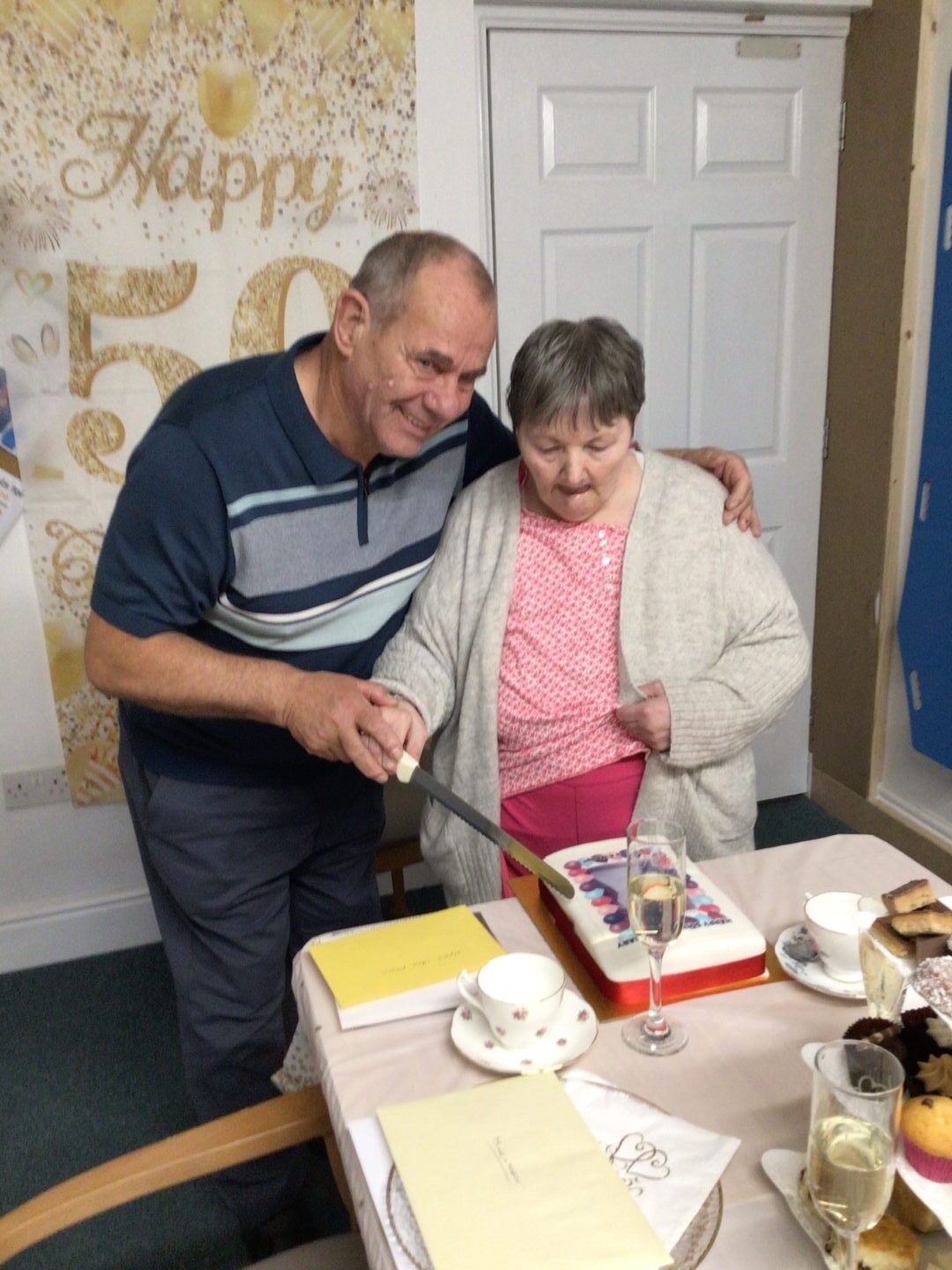 Mike and Madge cutting a cake to celebrate their 50th wedding anniversary 