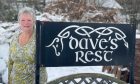 Janet Turnbull next to a Dave's Rest sign