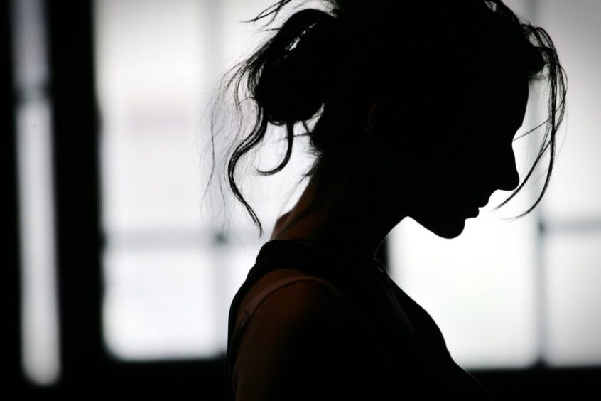 Silhouette of woman's head with waving hair, back light.