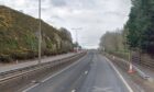 A view of the tree lined and empty A9 northbound with vehicles approaching from the distance.