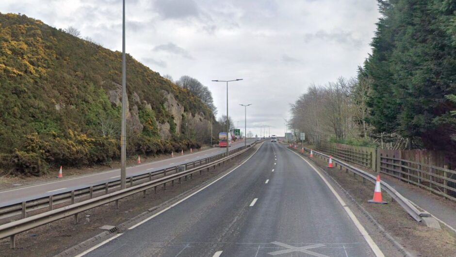 A view of the tree lined and empty A9 northbound with vehicles approaching from the distance.