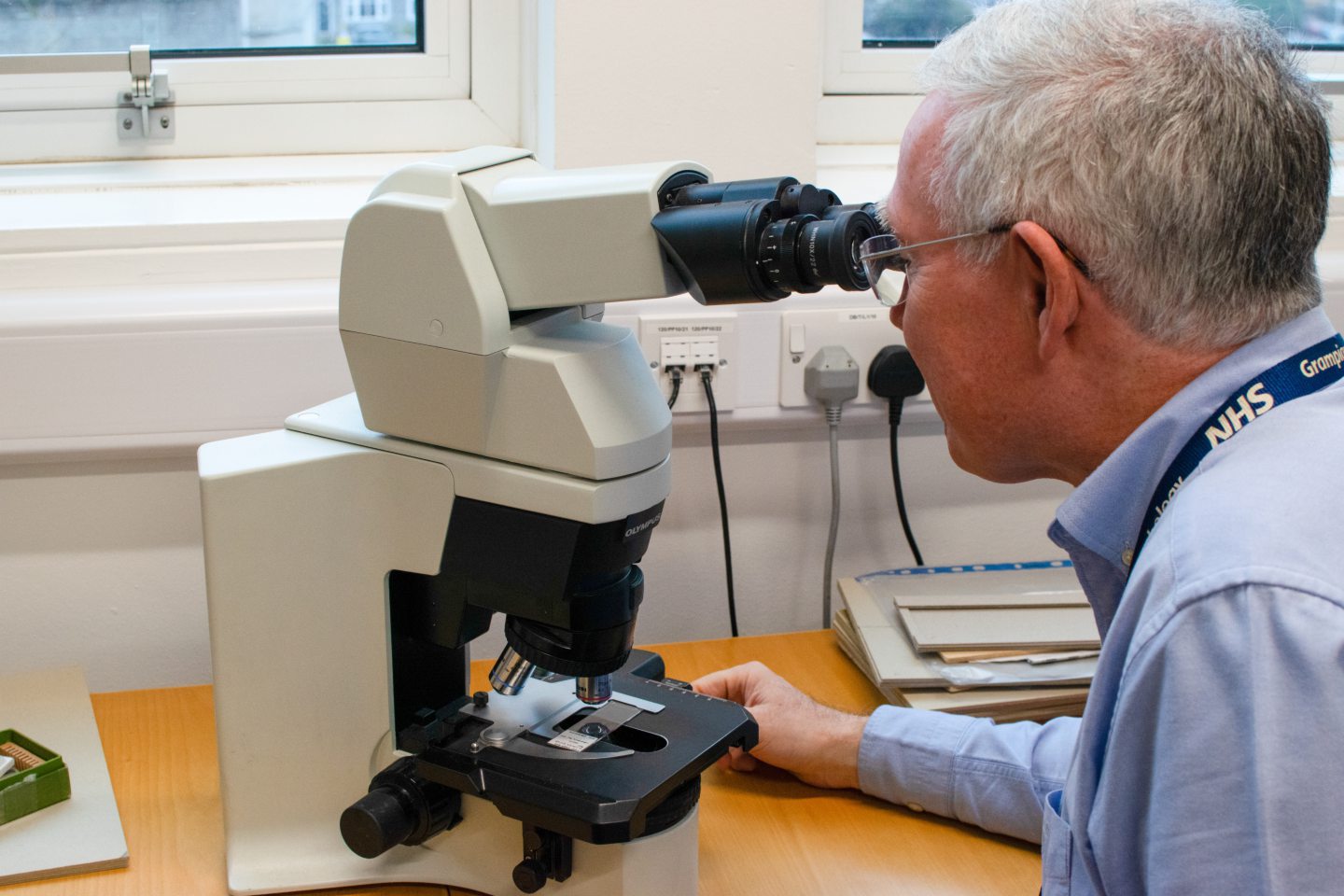 George King looking through a microscope