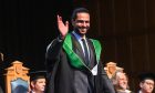 A graduate waves to family and friends from the stage at Elphinstone Hall. All images: Darrell Benns/DC Thomson