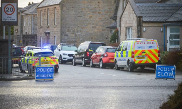 Police vehicles and blue 'police incident' and 'police slow' signs.