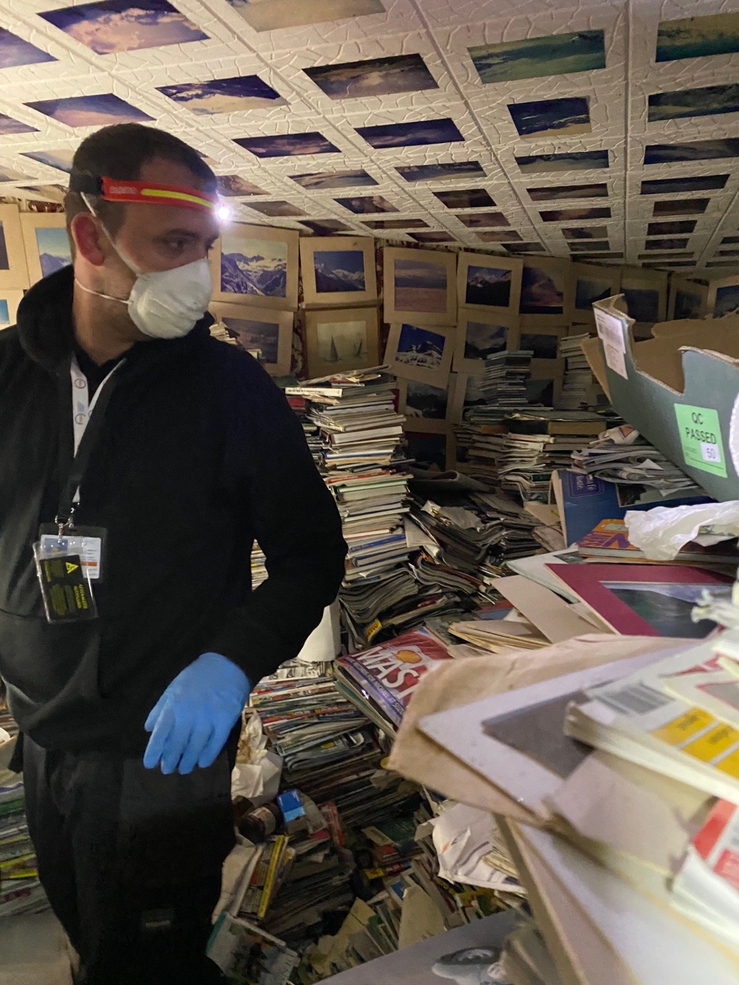 Andrew Irvine from Aftermath Scotland surrounded by piles of books and magazines