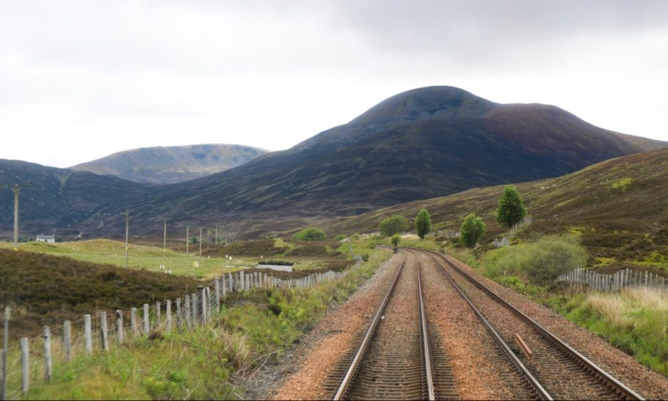 View along railway line in a remote location with hills ahead.