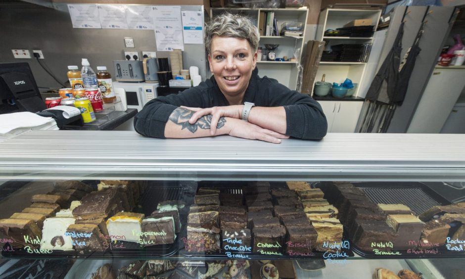 Gayle Johnstone leaning on counter inside Crofter's Neuk. 