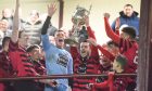 Calum Dingwall, centre, lifts the Evening Express Aberdeenshire Cup last season after Inverurie Locos' victory.