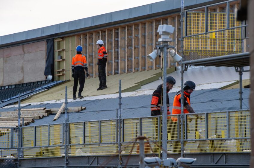 The image shows workers on a scaffolding at Tillydrone school, which is currently under construction. 