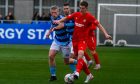 Colin Williamson, right, of Brora Rangers tries to get away from Banks o' Dee's Mark Gilmour. Pictures by Kenny Elrick/DCT Media.