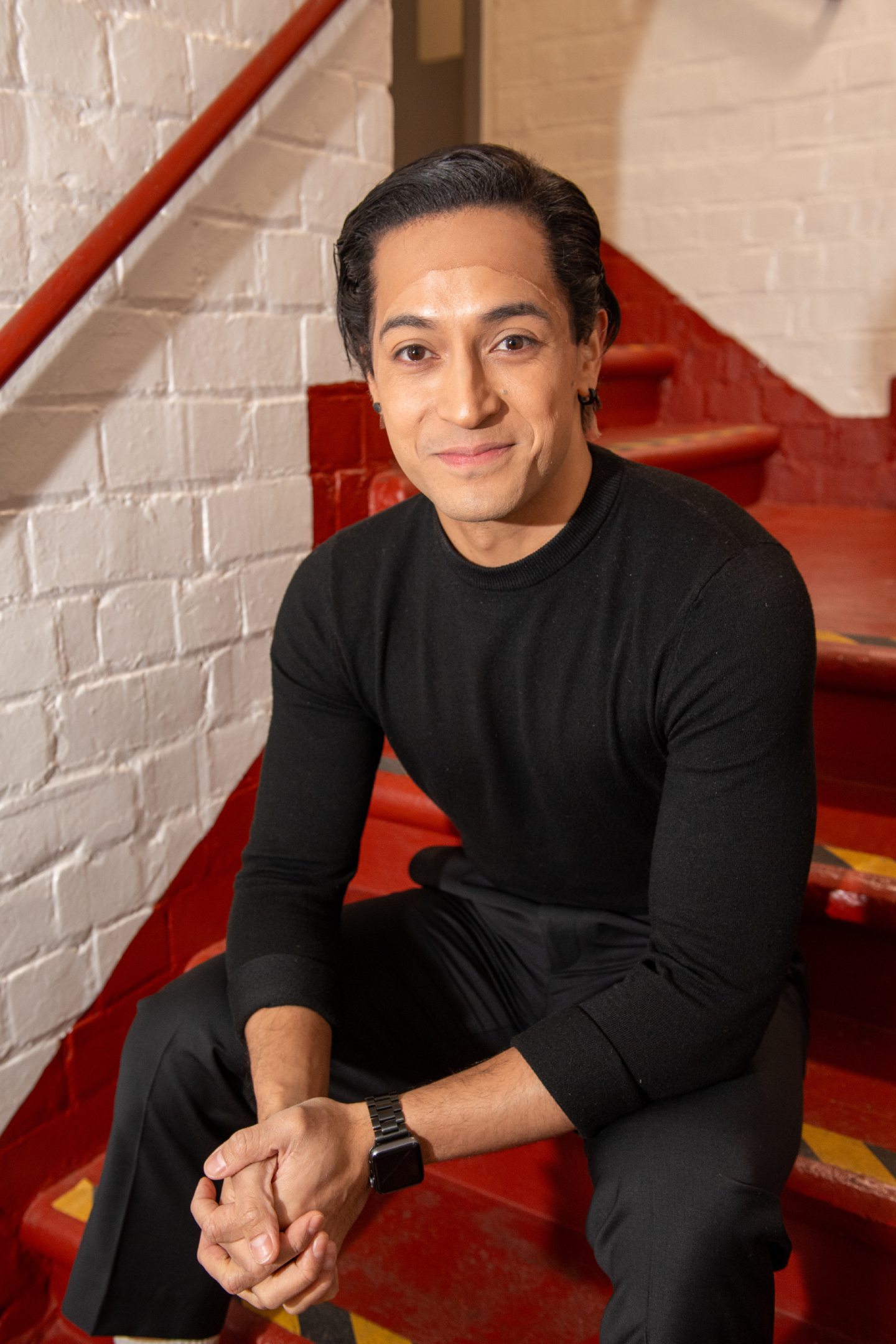 Filipe Manu on the stairs behind the stage at His Majesty's Theatre in Aberdeen. 