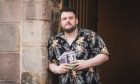 Martin Bearne standing in an old doorway in Edinburgh with flyers for his show during the Edinburgh Festival Fringe. Comedy by Claire Clifton Coles -18.jpg