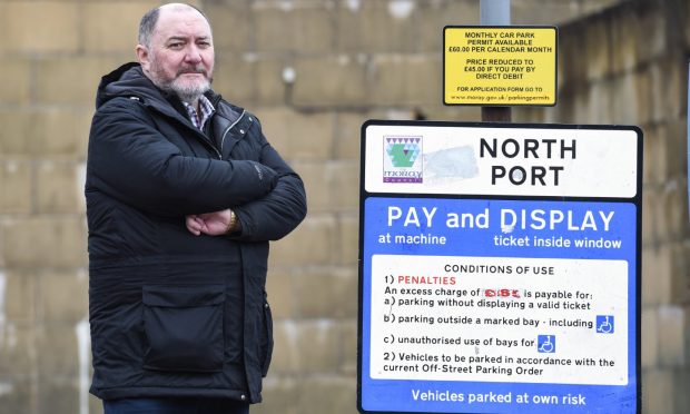 John Divers standing at Elgin car park sign.