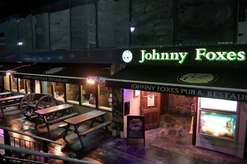 Facade of Johnny Foxes in Inverness, with picnic benches out of the front of the building.