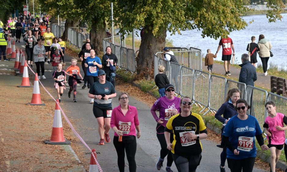 People running along the banks of River Ness in Loch Ness Marathon.