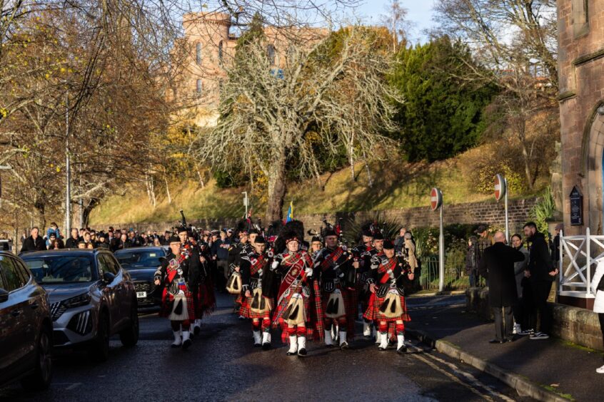 Pipe band lead parade down Ness Bank