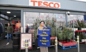 Woman protesting outside Tesco in Stornoway, Lewis, as it opens on Sunday for the first time.