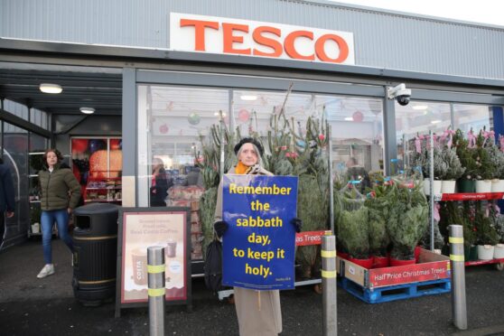 Woman protesting outside Tesco in Stornoway, Lewis, as it opens on Sunday for the first time.