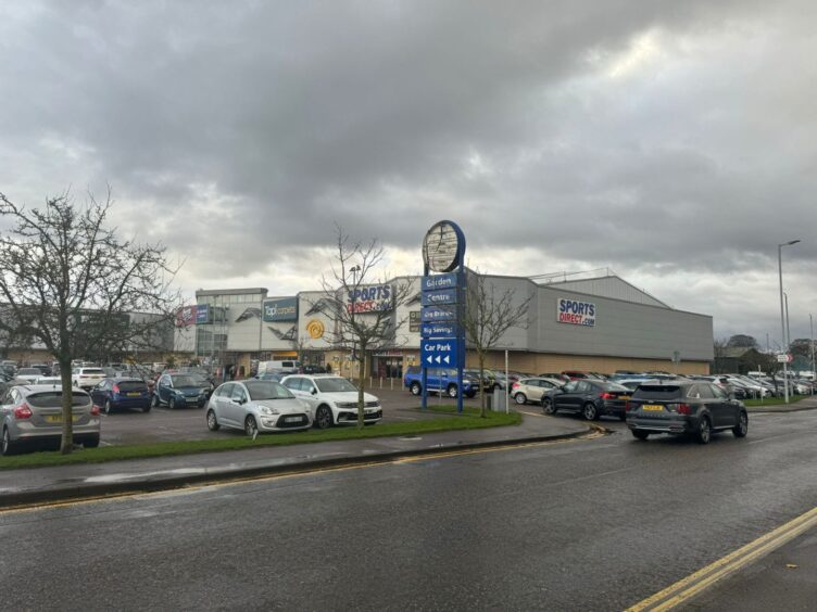 View of retail park anc broken blue B&M sign.