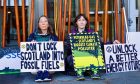 Extinction Rebellion campaigners locked themselves to the Scottish Parliament.