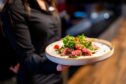 Waitress carrying plate of food.