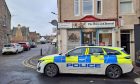 Police car parked outside Greig Street Newsagents.