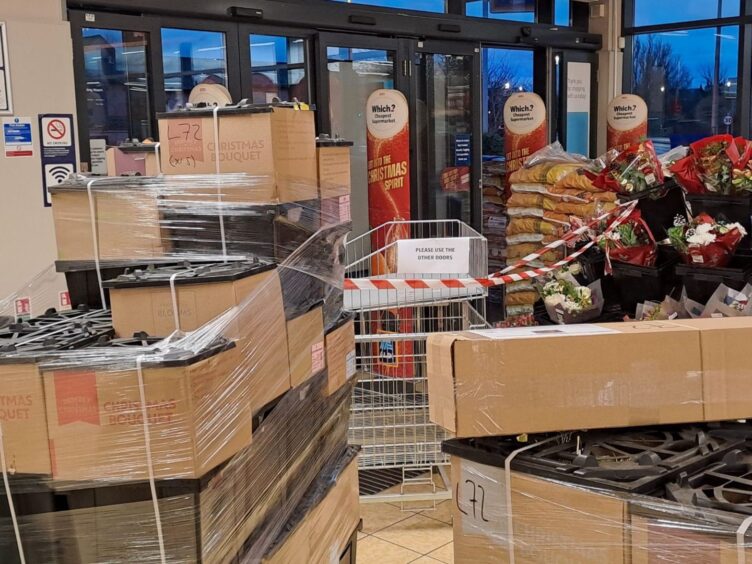 Boxes and stock piled up near main entrance to block entry through smashed door.