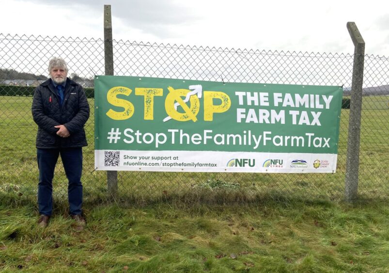 NFU Scotland president Martin Kennedy next to a #StopTheFamilyFarmTax banner