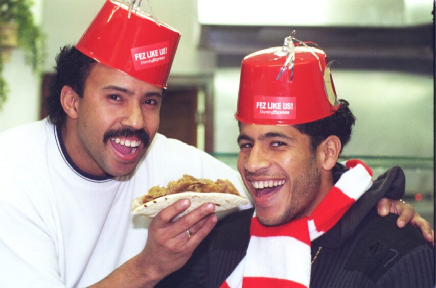 Aberdeen's Moroccan star Hicham Zerouali wears an Evening Express fez as he pays his city restaurant pal Mustapha Wahbi a visit.