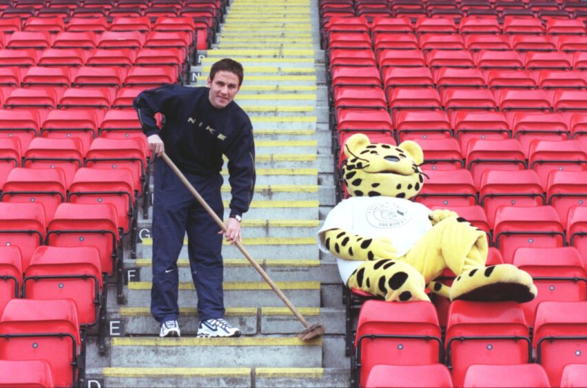 Eoin Jess sweeping up to launch the National Spring Clean at Pittodrie, along with Spot the leopard.